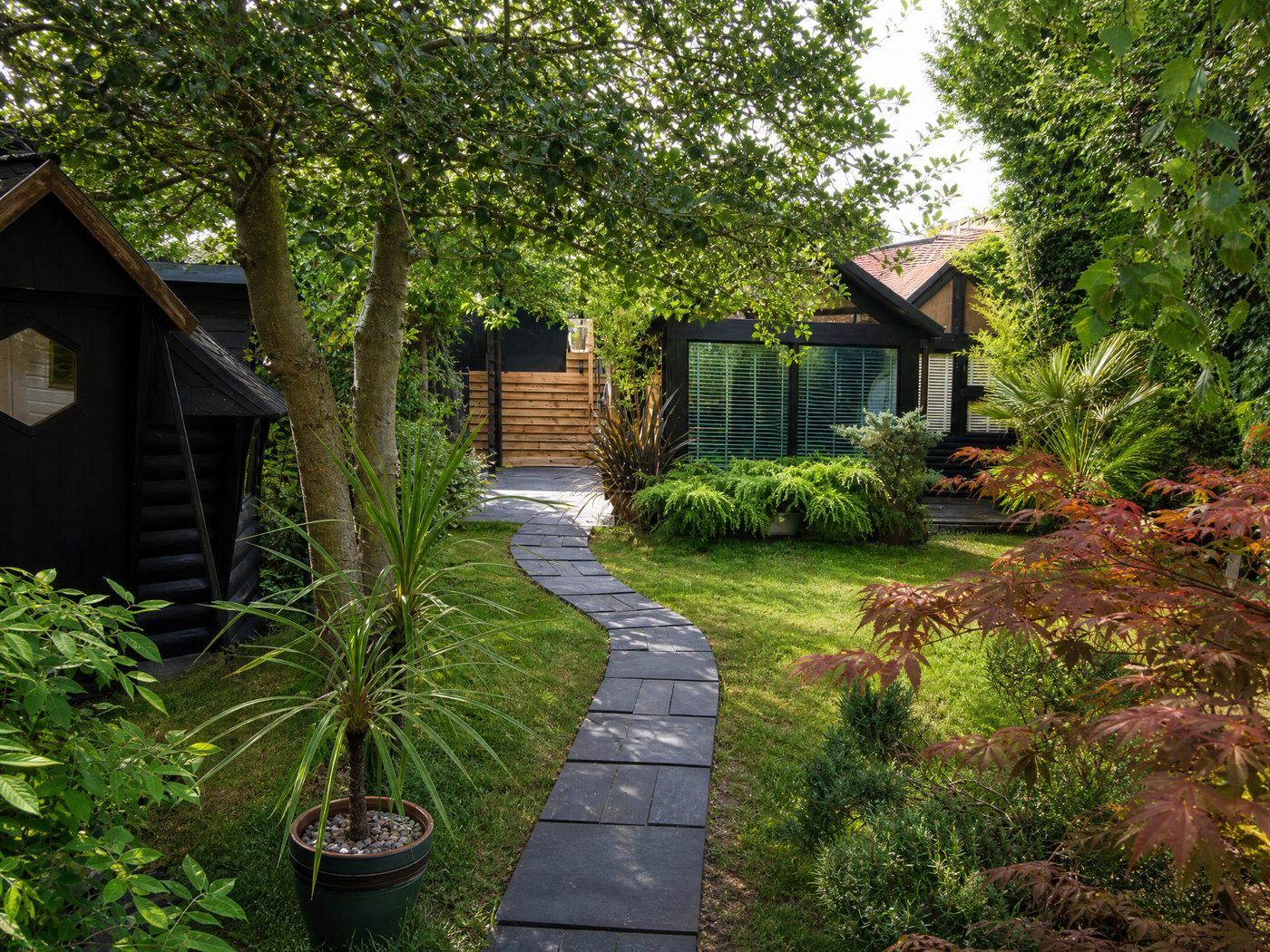Secluded garden approach with mature trees and stone path